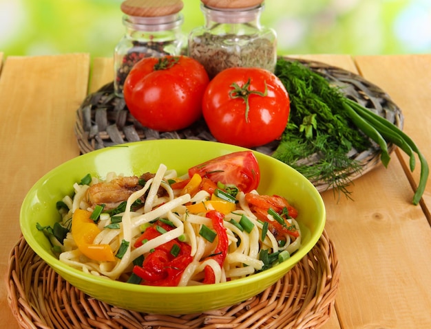 Tagliatelle con verdure nel wok sullo sfondo della natura