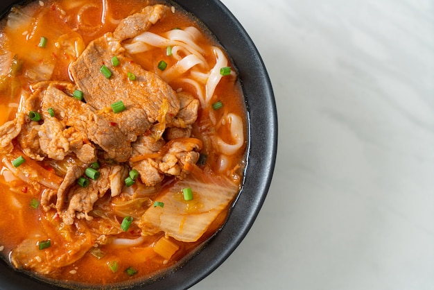 Tagliatelle coreane di ramen udon con carne di maiale in zuppa di kimchi - Stile di cibo asiatico