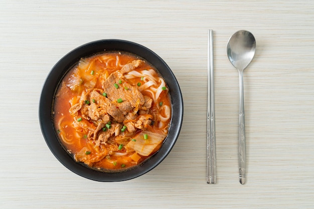 Tagliatelle coreane di udon ramen con carne di maiale in zuppa di kimchi - stile asiatico