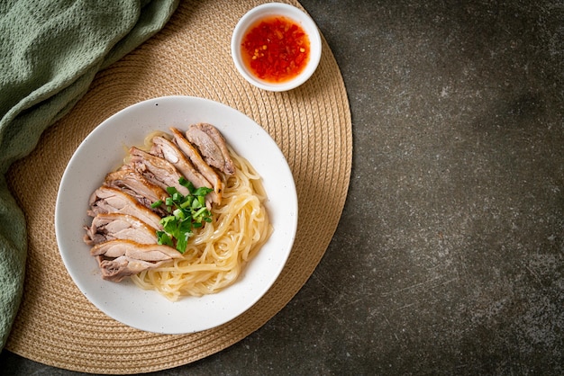 tagliatelle di anatra essiccate in una ciotola bianca - stile asiatico dell'alimento