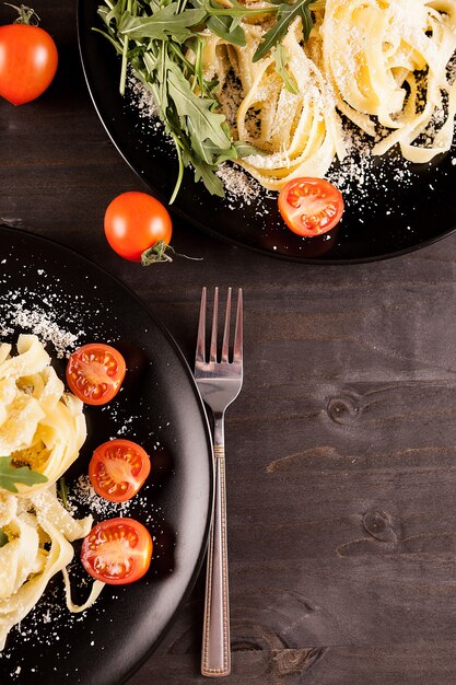 Tagliatelle di pasta sana con parmigiano su tavola di legno