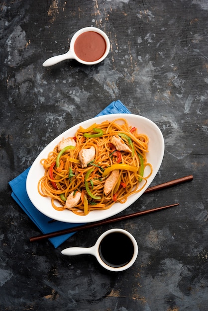 Tagliatelle di pollo Hakka o Schezwan servite in una ciotola con le bacchette. messa a fuoco selettiva