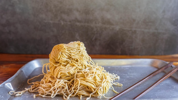 Tagliatelle gialle in un vassoio sul tavolo della cucina