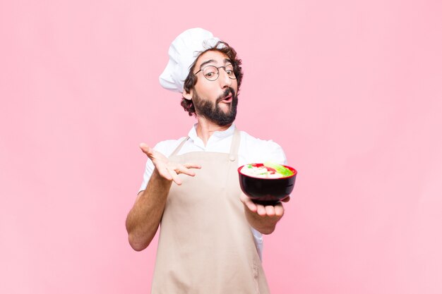 Tagliatelle giapponesi di cottura fresche pazze giovani contro la parete rosa