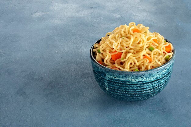 tagliatelle istantanee con carota e cipolle su uno sfondo di ardesia una ciotola di soba di verdure con copyspace