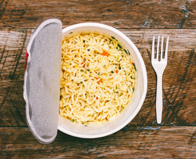 Tagliatelle istantanee su fondo di legno, primo piano vista dall&#39;alto