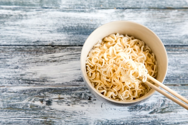 Tagliatelle istantanee su fondo di legno. Tagliatelle istantanee cinesi cotte.