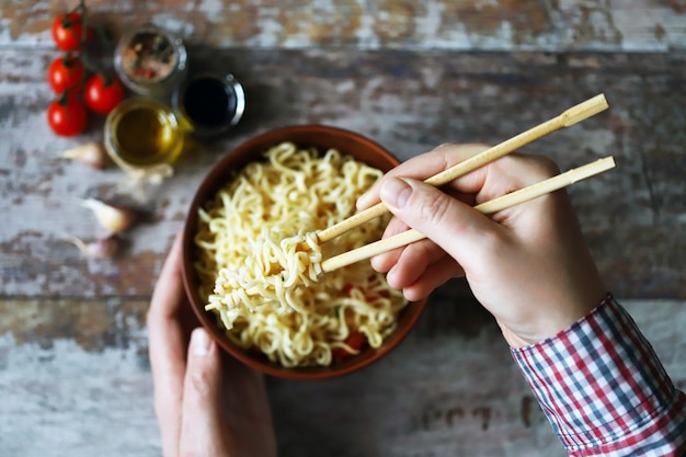 Tagliatelle mangiatori di uomini con le bacchette. Spaghetti cinesi.