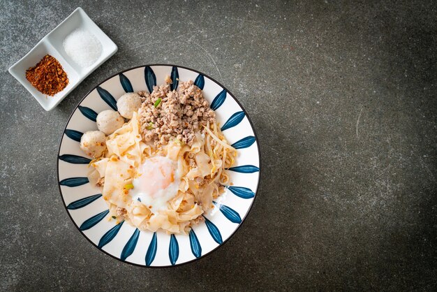 tagliatelle piccanti essiccate con carne di maiale macinata, polpette e uova - stile asiatico