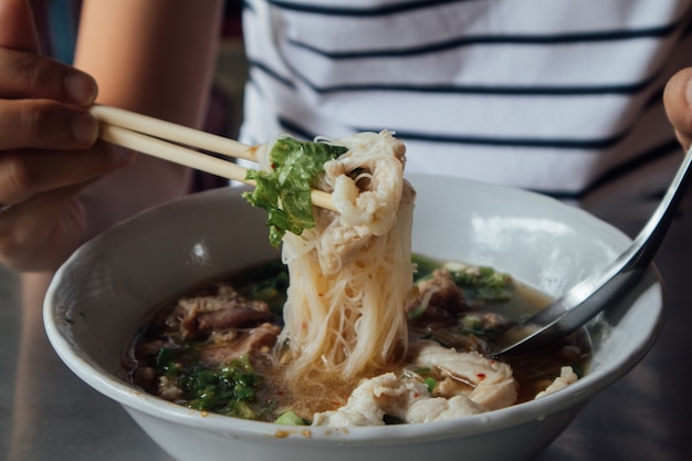 Tagliatelle piccanti tailandesi con carne di maiale e zuppa.