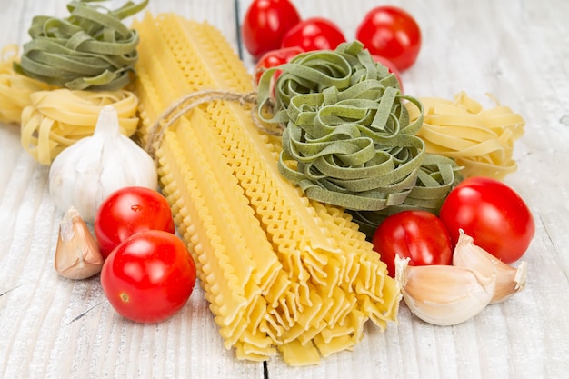 Tagliatelle pomodori e aglio su uno sfondo di legno