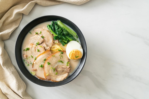 Tagliatelle ramen in zuppa di ossa di maiale con maiale arrosto e uova o tagliatelle ramen Tonkotsu - stile alimentare giapponese