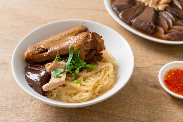 Tagliatelle secche con anatra brasata in una ciotola bianca