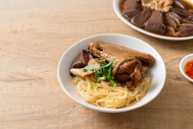 Tagliatelle secche con anatra brasata in una ciotola bianca