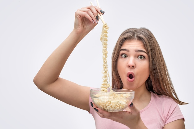 Tagliatelle stupite della stretta della giovane donna con le bacchette