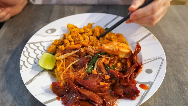 Tagliatelle tailandesi con gamberi e ragù di carne da vicino.