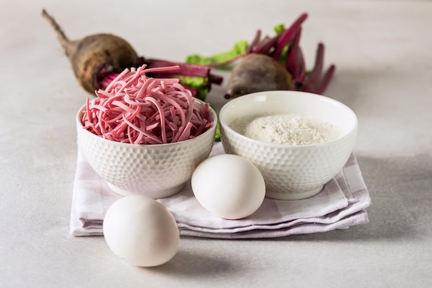 Tagliatelle turche fatte a mano con barbabietola rosa tagliatella sana vegan noodle sfondo grigio uova