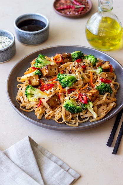 Tagliatelle Udon con tofu broccoli carote pepe e sesamo Alimentazione sana Cibo vegetariano Cibo asiatico