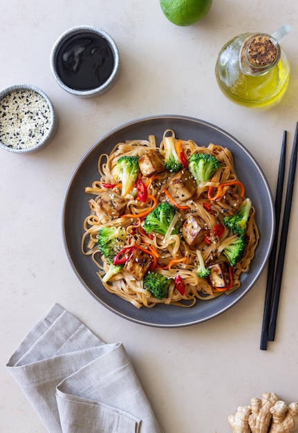 Tagliatelle Udon con tofu broccoli carote pepe e sesamo Alimentazione sana Cibo vegetariano Cibo asiatico