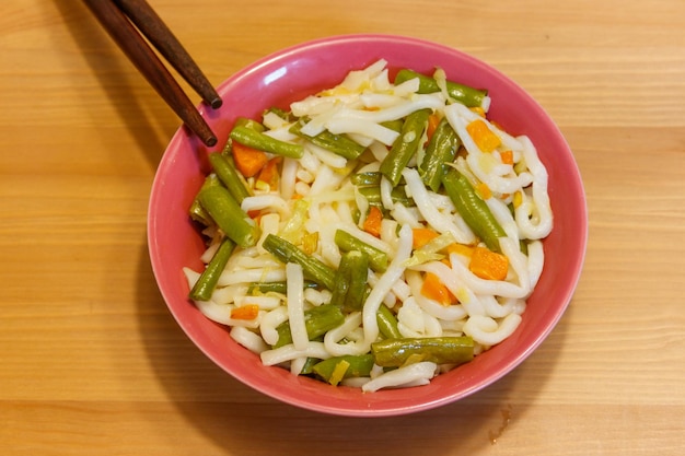 Tagliatelle Udon con verdure su tavola di legno Cucina giapponese Cucina asiatica