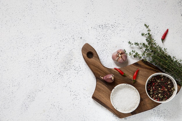 tagliere con erbe su cemento bianco