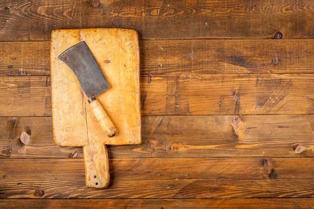 Tagliere con i vecchi coltelli da cucina in tavola di legno