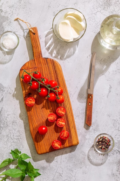 Tagliere da cucina con pomodori interi e tagliati Vista dall'alto del concetto di cucina casalinga