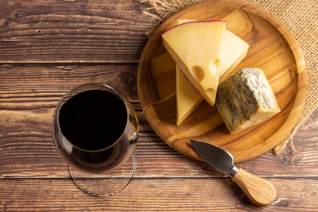 Tagliere di formaggi con un bicchiere di vino rosso