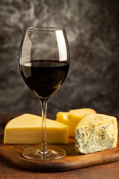 Tagliere di formaggi con un bicchiere di vino rosso