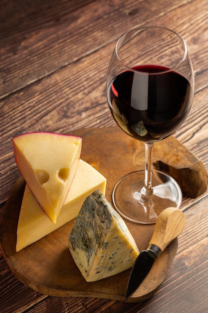 Tagliere di formaggi con un bicchiere di vino rosso