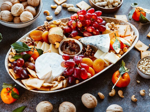 Tagliere di formaggi grande con assortimento di antipasti Marmellata di noci e formaggio d'uva e pane