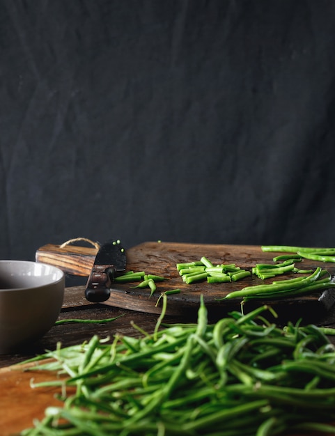 Tagliere di legno crudo del fagiolo verde Alimento vegetariano sano