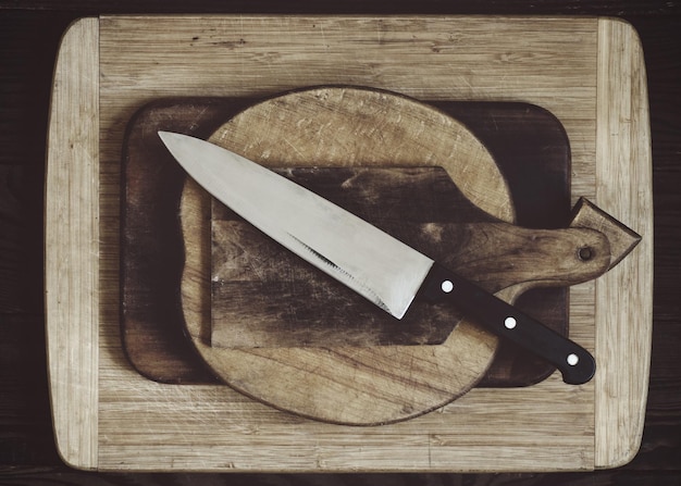 Taglieri in legno di varie dimensioni e forme e coltello da cucina. Vista dall'alto