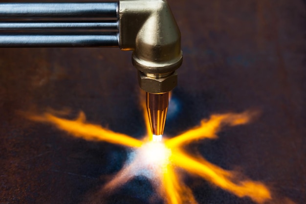 Taglio a gas con ugello in rame con getto di fuoco diretto al metallo che riscalda il metallo con taglio a gas