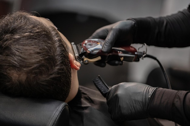 taglio di capelli di un uomo in un negozio di barbiere