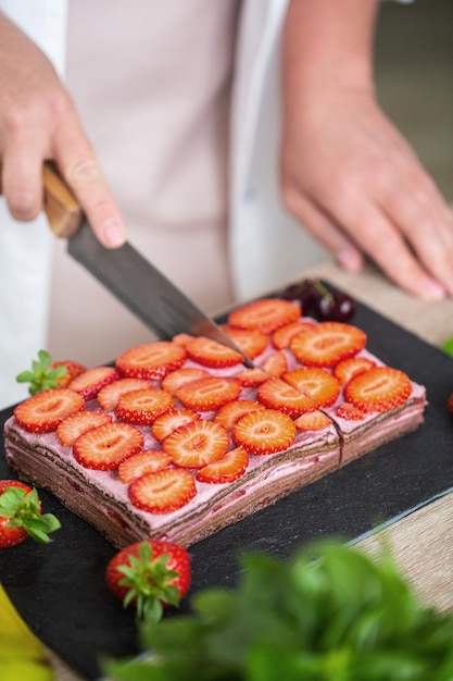 Taglio di cheesecake crudo senza cottura, realizzato con datteri, anacardi e fragole, foto di alta qualità