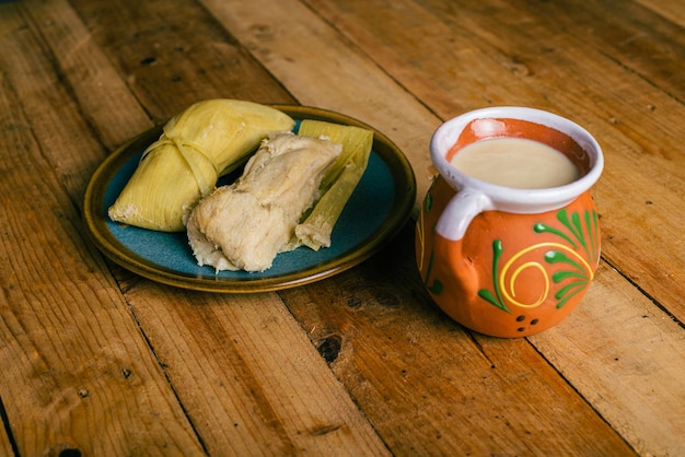 Tamales de elote e atole su un tavolo di legno Cibo tipico messicano