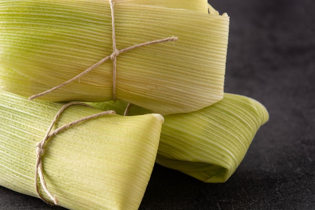 Tamales messicani di mais e pollo su sfondo nero