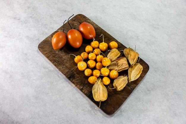 tamarillo o pomodoro albero su tavola di legno accanto a uvilla o aguaymanto physalis