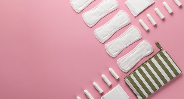 Tamponi, assorbenti femminili su uno sfondo rosa. Cure igieniche nei giorni critici. ciclo mestruale.