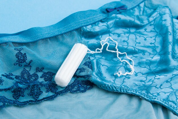 Tamponi bianchi su sfondo blu. Igiene della donna