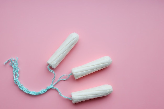 Tamponi femminili medici su uno sfondo rosa. Tampone bianco per le donne.