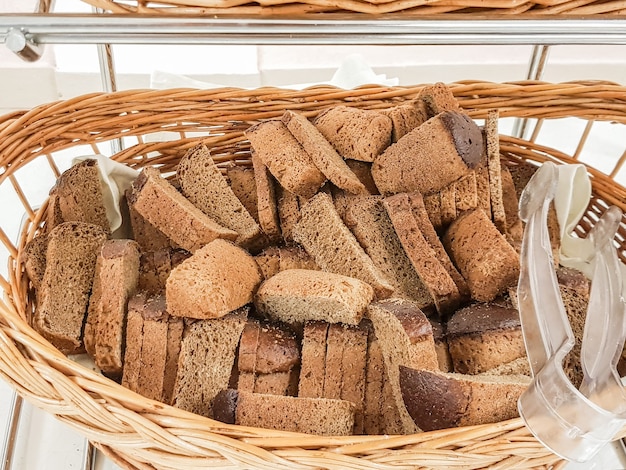 Tante fette di pane nero in un cesto di vimini