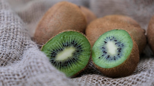 Tanti kiwi su un sacchetto di tela ecologica rustica e un kiwi tagliato a metà