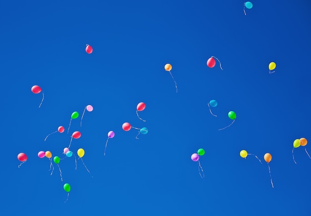 Tanti palloncini colorati che volano nel cielo azzurro