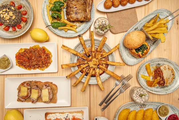 Tapas spagnole e latino-americane strisce di melanzane con hummus e sciroppo di canna lombata e toast al formaggio crocchette assortite Empanadas di mais colombiano costine con patatine fritte e peperoni padron