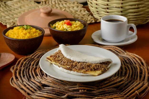 Tapioca di carne al sole e ricotta, con uova e cous cous. Colazione tipica del nord-est brasiliano.