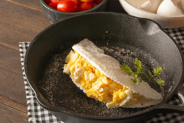 Tapioca Pancake con uova Cibo di manioca brasiliano in alto vista anteriore all'interno della padella d'acciaio