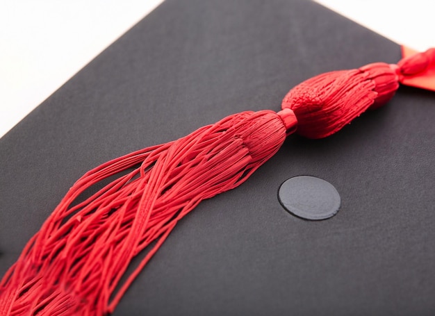 Tappo di graduazione con nappa d'oro isolato su sfondo bianco