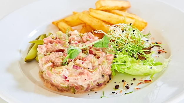 Tartare di carne con patatine fritte e insalata di verdure